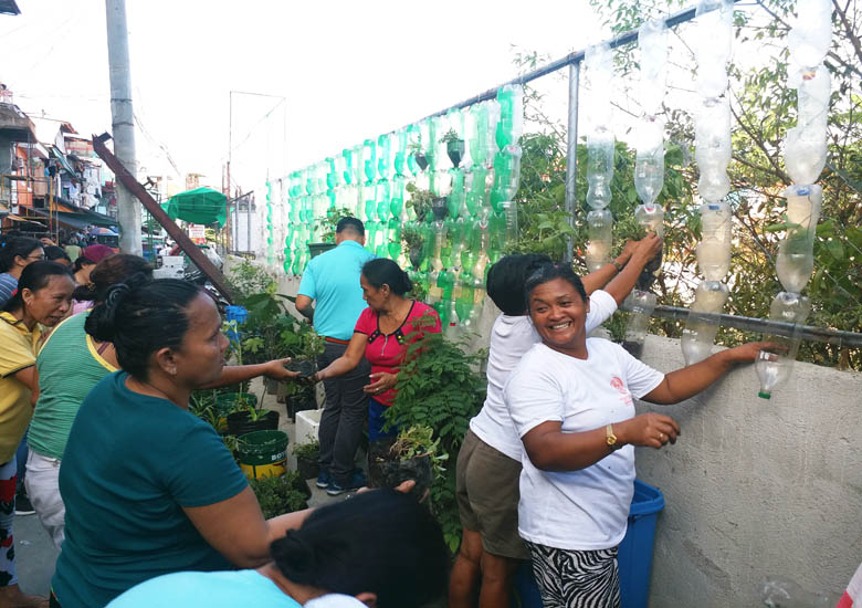 five people planting in a vertical garden