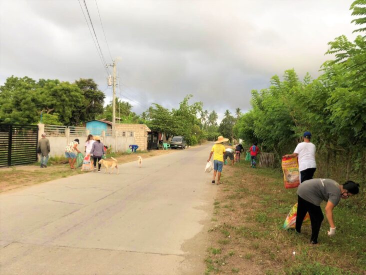 Cluster members picking up trash by the roadside