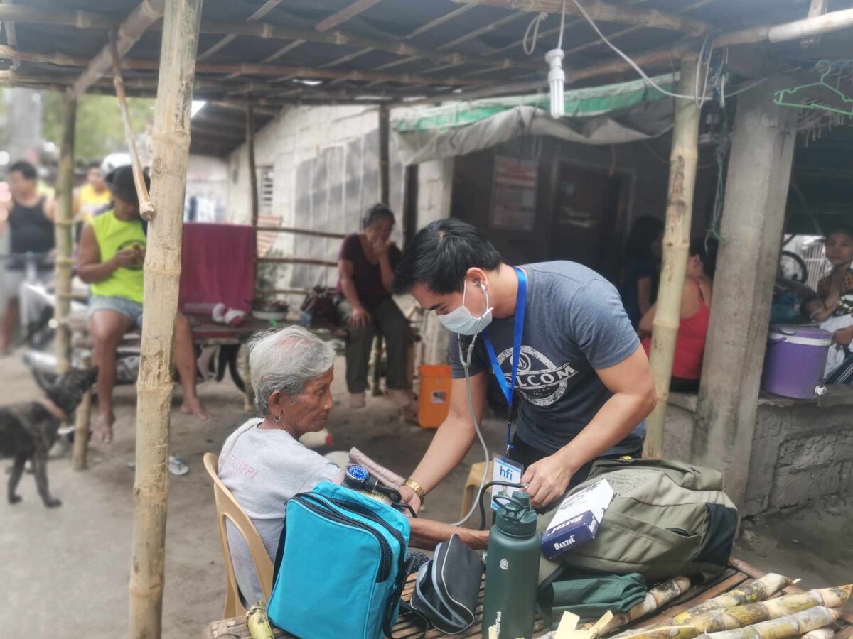 Nurse Cliff measures the blood pressure of a community member during their house-to-house visits in Barangay Maasin, Pura, Tarlac