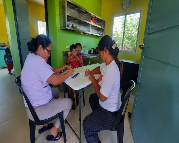 Barangay Health Workers (BHWs) interviewing the guardian of the patient to fill out the personal record form and medical history of the patient in Barangay Recuerdo, Nampicuan, Nueva Ecija