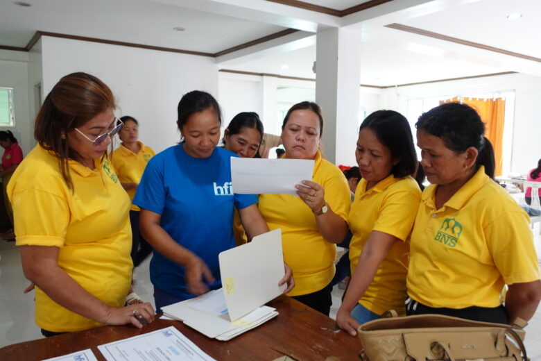 Ms. Joan endorses forms for Malinao’s Barangay Nutrition Scholars during Dietary Supplementation distribution.