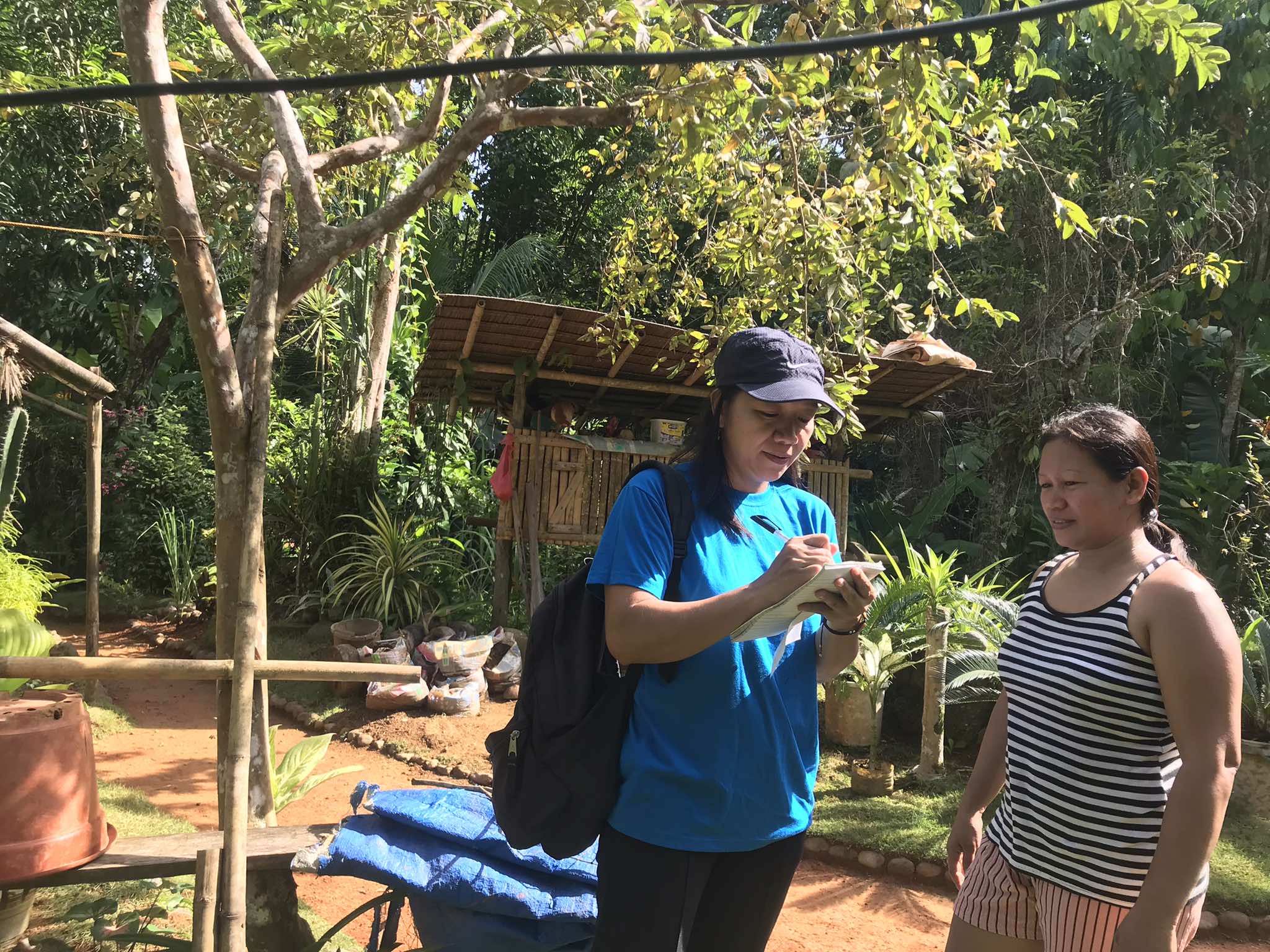 HFI Community Mobilizer is interviewing a nutrition garden beneficiary in Barangay Manhanip to monitor the progress of her garden and gather feedback